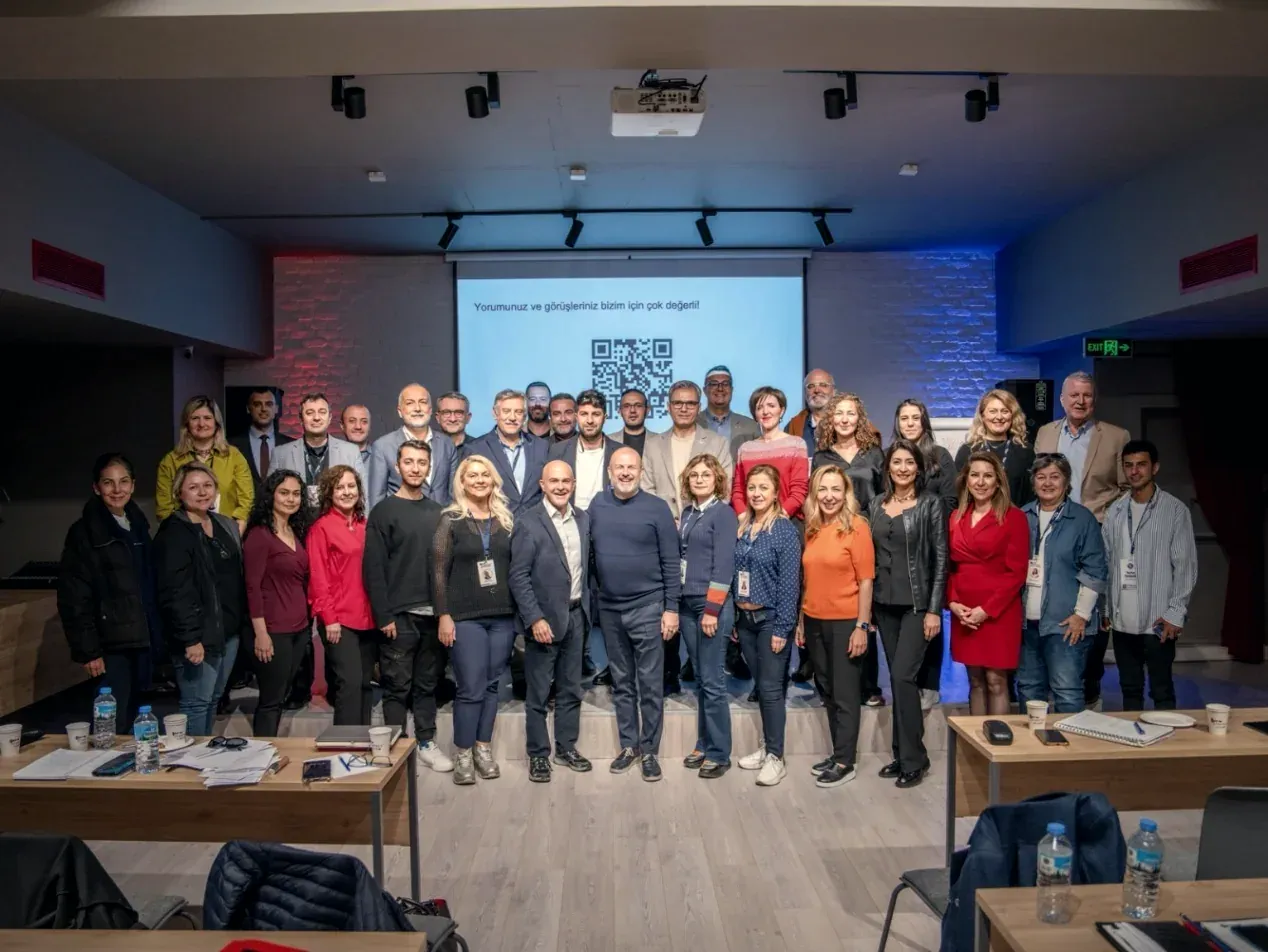 Bir eğitimin katılımcıları sınıfta grup fotoğrafı çektiriyor